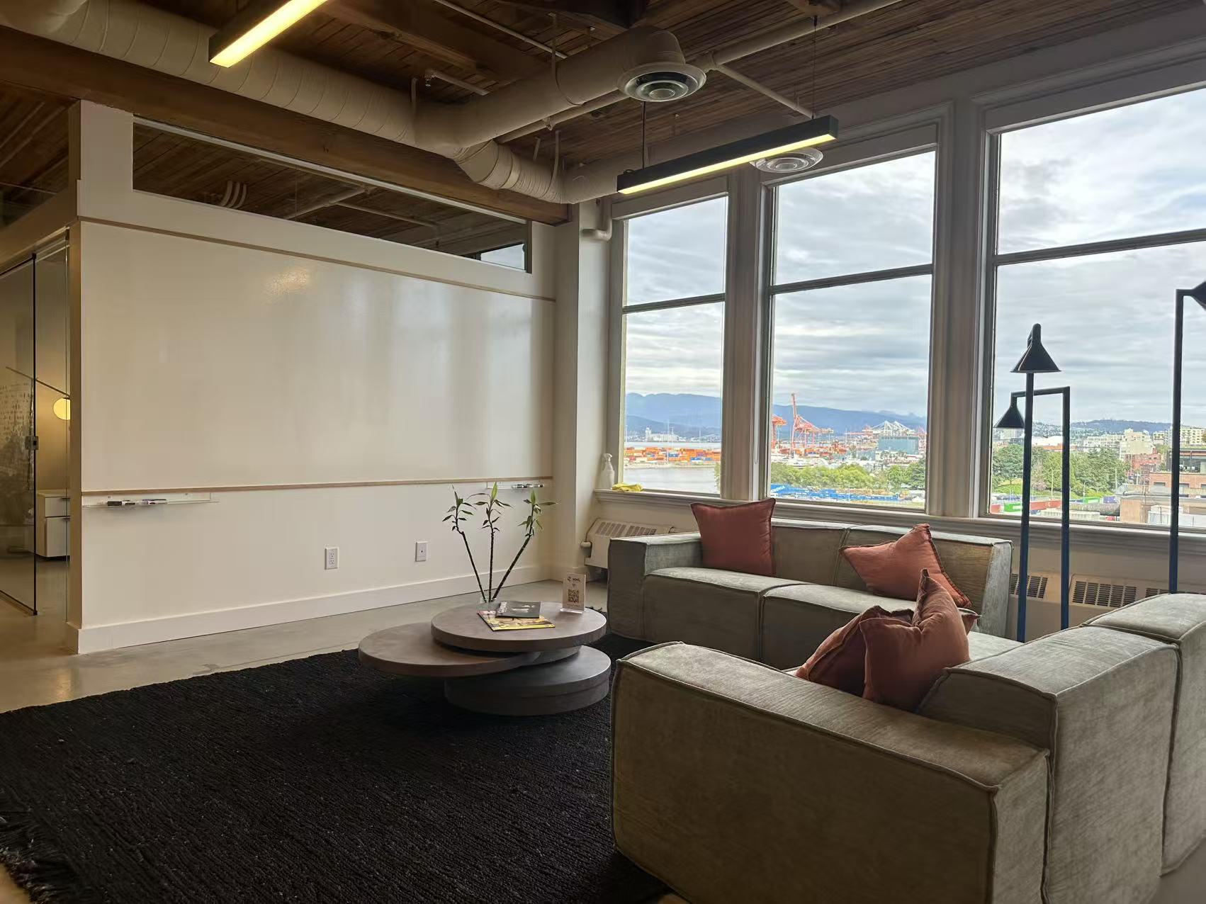 Lounge seating beside the wall whiteboard, with harbour views